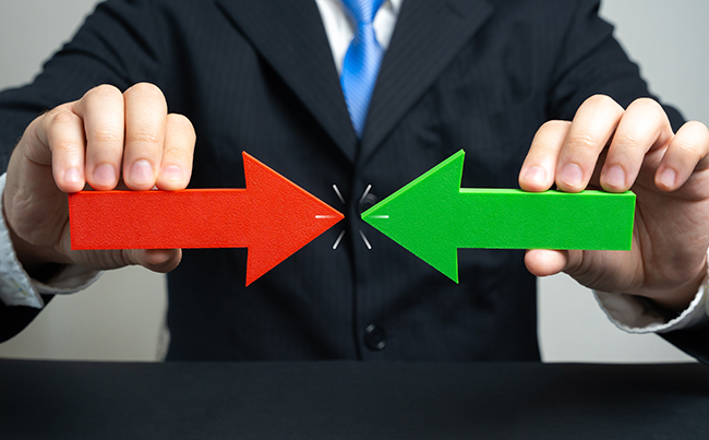 Mann mit Pfeilen rot und grün in der Hand, die sich auf einander zu bewegen.